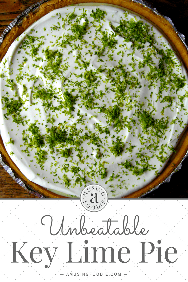 Fresh lime zest on top of homemade key lime pie with a sour cream topping and graham cracker crust.