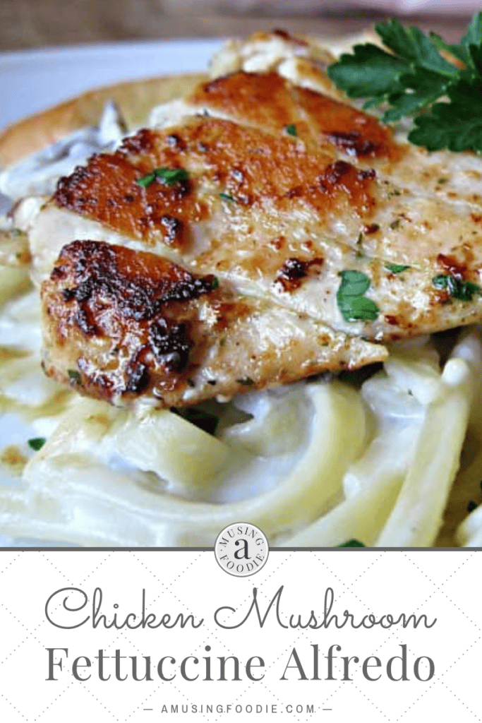 Close up of sliced chicken breast on top of pasta with alfredo sauce.