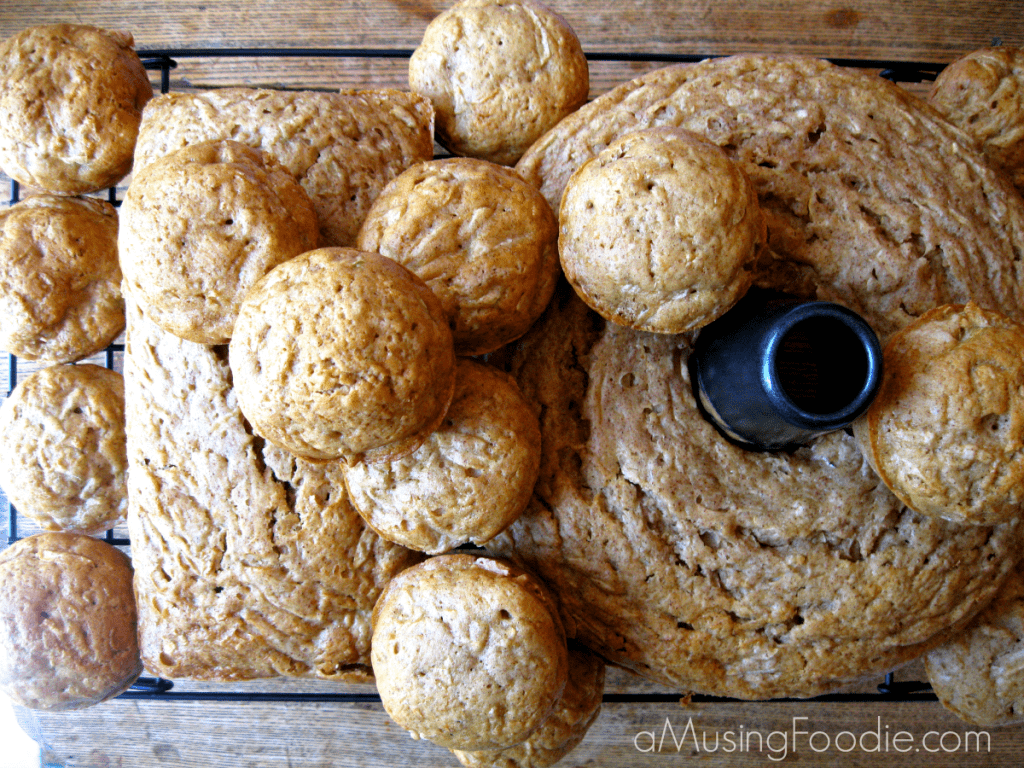 How to Make Zucchini Bread Zucchini bread, muffins and tube pan cake sitting on a cooling rack atop a wooden table.