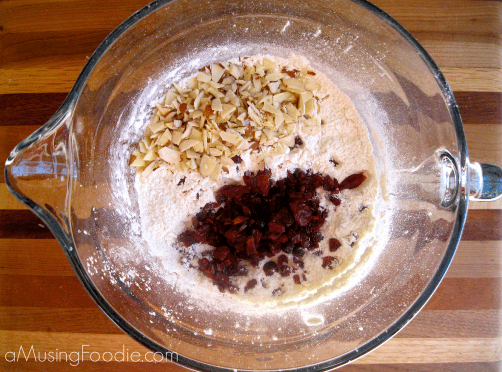 Cranberry Almond Zucchini Mini Muffins Dry ingredients with dried cranberries and slivered almonds in a mixing bowl.