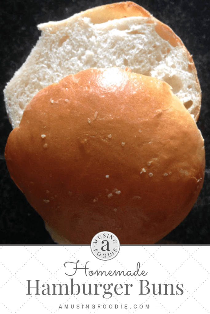 Close up shot of a homemade hamburger bun, sliced, on a dark counter.