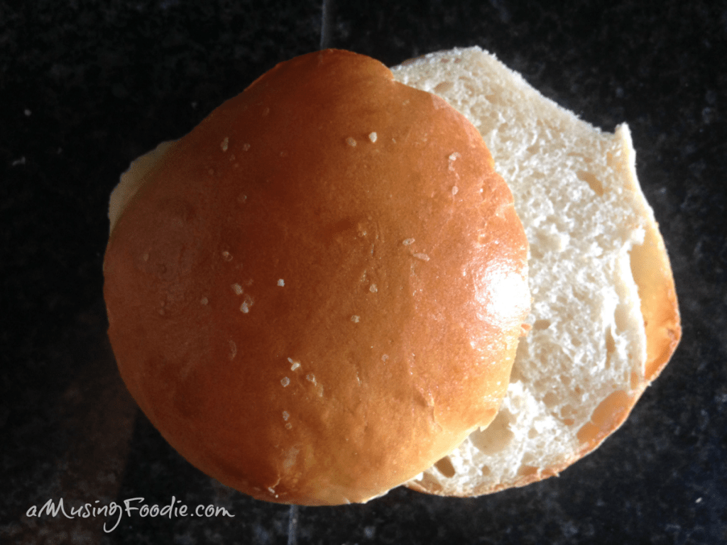 Sliced hamburger bun on a dark table.