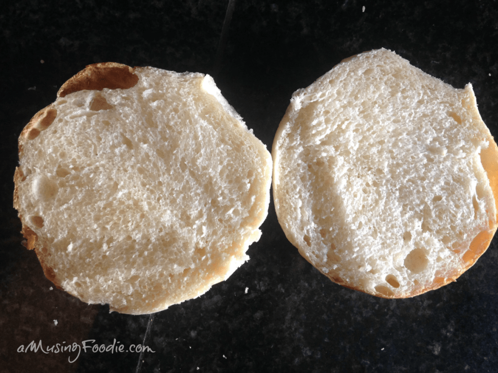 Sliced fresh homemade hamburger bun on a dark counter.