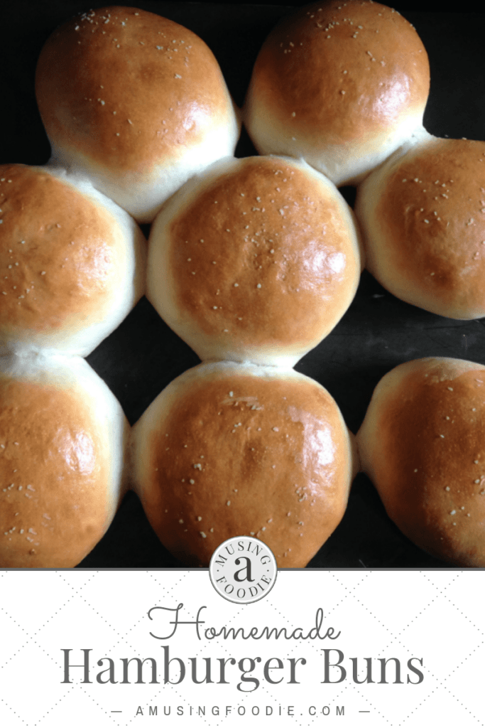 Eight hamburger buns on a dark counter.