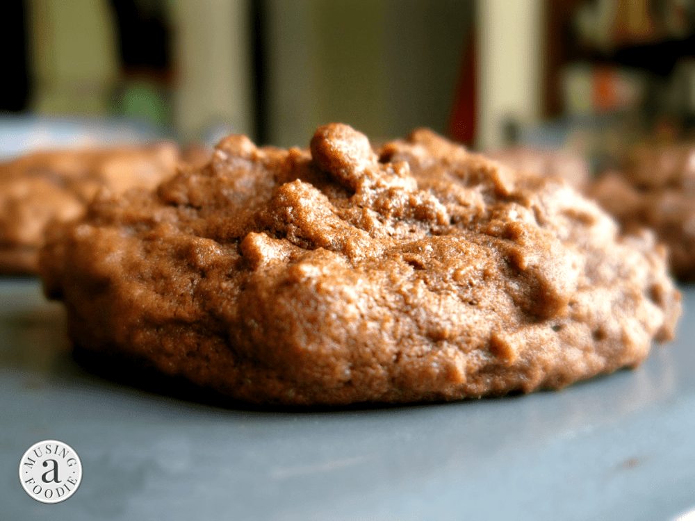Close up side photo of a chocolate cookie on a baking sheet.
