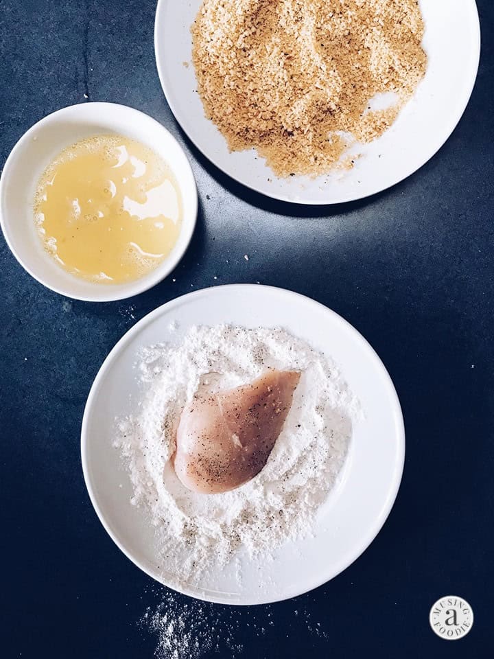 Chicken getting ready to be dredged in flour, egg and panko breadcrumbs.