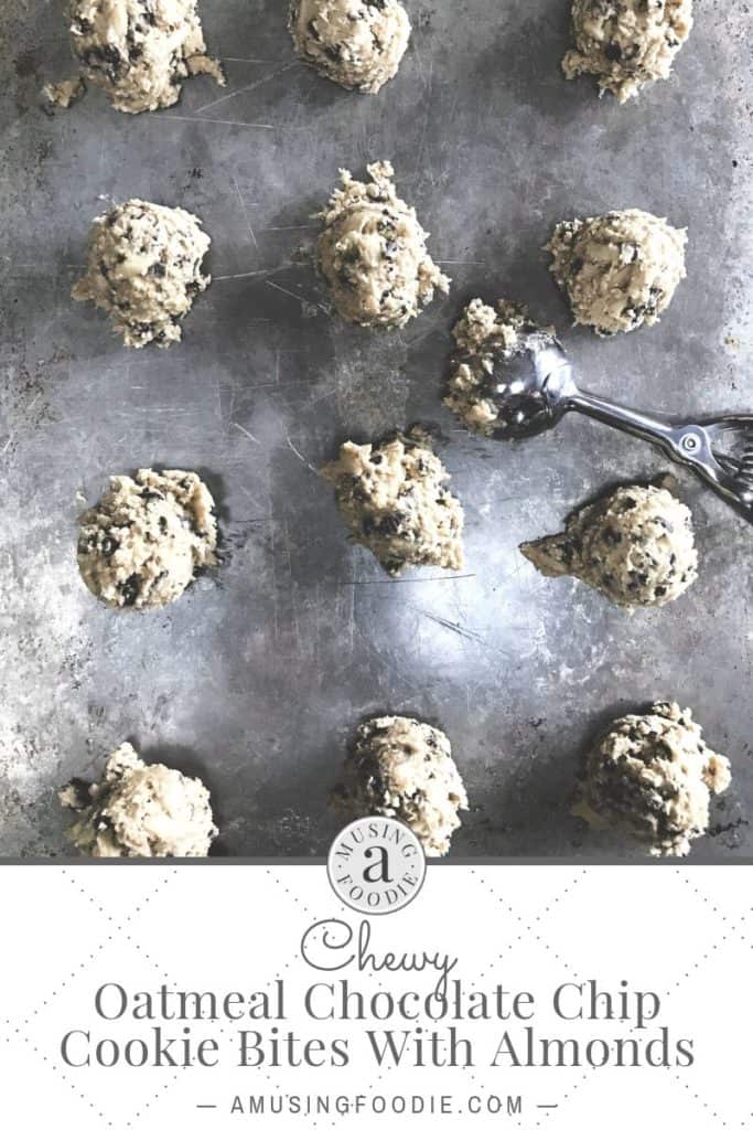 Scoops of oatmeal chocolate chip cookie dough with almonds on a baking sheet.