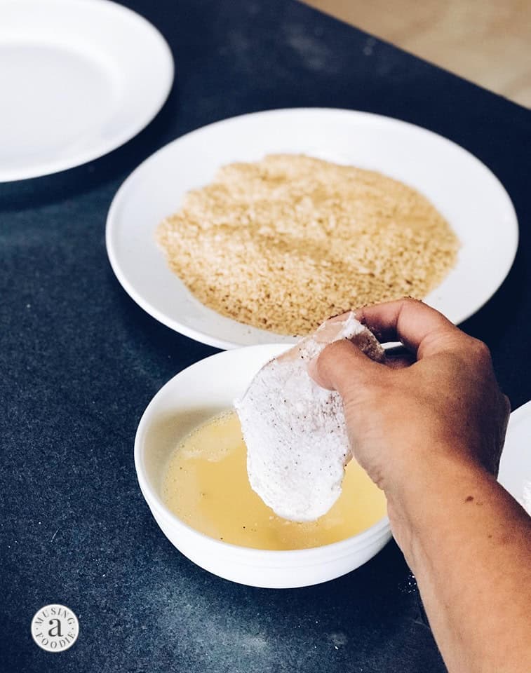 Chicken breast dredged in flour and ready to be dipped in egg.